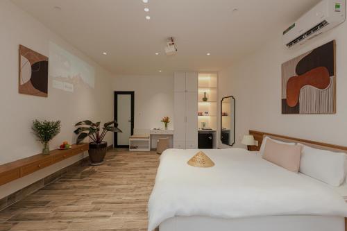 a bedroom with a large white bed and a bathroom at Valley De Mango Hue in Thôn Châu Chữ