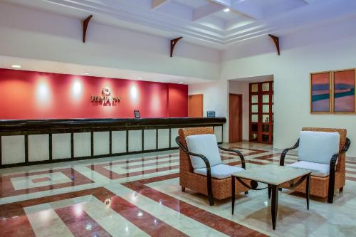 a lobby with two chairs and a bar at Fiesta Inn Tampico in Tampico