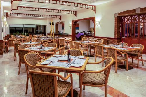 a dining room with wooden tables and chairs at Fiesta Inn Tampico in Tampico