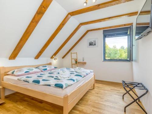 a bedroom with a bed and a window at Four Bedroom Holiday House Mali Raj with Pool in Oštarije