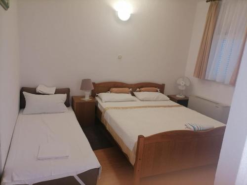 a bedroom with two beds and a window at Apartments Libertas - Studio with Balcony and Sea View - 3 in Rogoznica