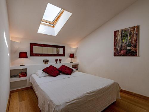 a bedroom with a white bed with a skylight at Stone House Anfitrite - Two Bedroom Villa with Private Pool and Terrace in Trstenik