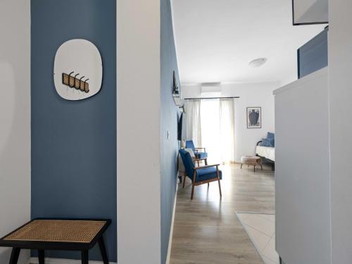 a living room with a blue wall and a mirror at One-Bedroom Apartment With Pool in Brodarica