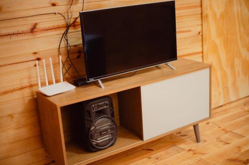 ファホウピーリャにあるRefúgio dos Capitéisのコンピューターが置かれた木製のキャビネットの上に置かれたテレビ