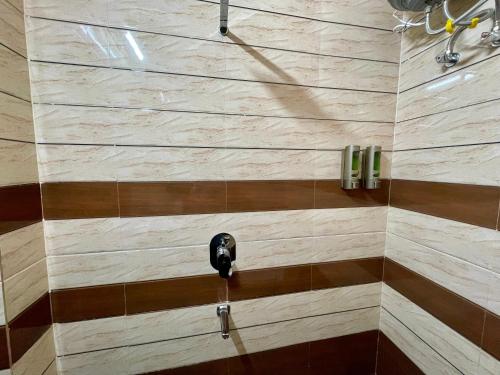 a bathroom with a shower with a black handle at Hotel Kashi Awahan! Near Vishvanath Temple in Varanasi