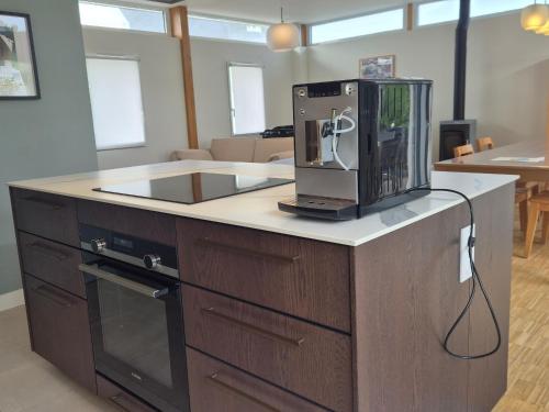 a kitchen with a microwave on top of a counter at Superbe maison neuve à Groix, proche bourg - FR-1-813-2 in Groix