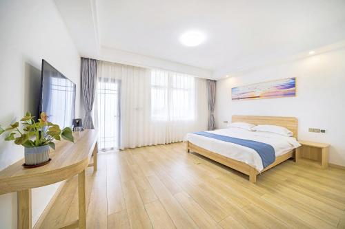 a bedroom with a bed and a desk in it at Qianxun Tea House & Homestay in Wuyishan