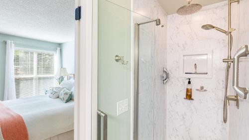 a bedroom with a bed and a shower with a glass door at Mutiny Bay Condo by AvantStay Walk to the Beach in Freeland