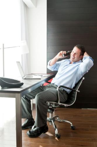 a man sitting at a desk talking on a cell phone at Fiesta Inn San Luis Potosi Glorieta Juarez in San Luis Potosí