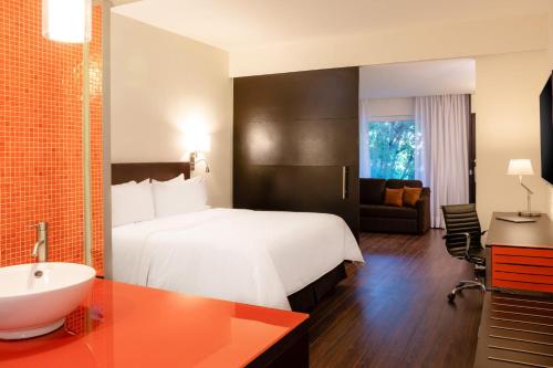 a hotel room with a white bed and a sink at Fiesta Inn San Luis Potosi Glorieta Juarez in San Luis Potosí