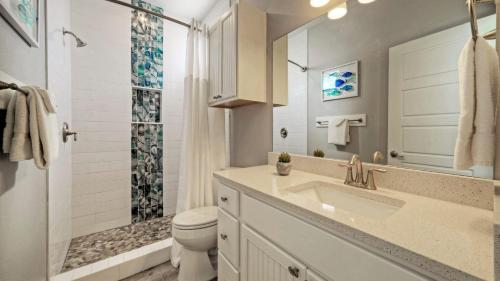 Un baño con lavabo, inodoro y ducha. en Island Paradise by AvantStay Pool Island Views, en Port Aransas