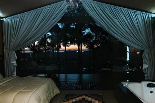 a bedroom with a bed and a tub and a window at Cabana Vista Ilha/Santo Amaro da Imperatriz in Santo Amaro da Imperatriz