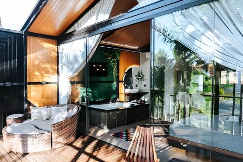 a house with a glass walled patio with a bench at Cabana Vista Ilha/Santo Amaro da Imperatriz in Santo Amaro da Imperatriz