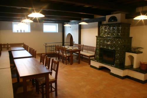 a restaurant with tables and chairs and a fireplace at Penzion u sklepů in Hovorany