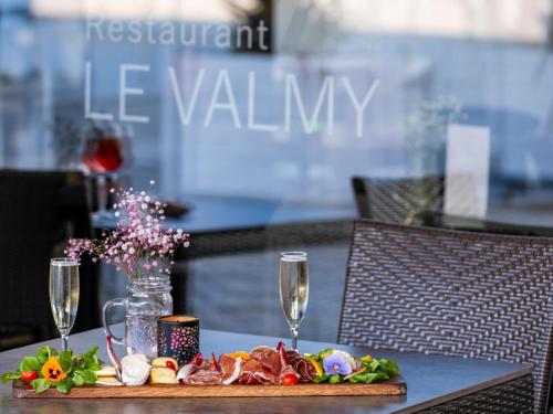 a table with a plate of food and two wine glasses at Novotel Nantes Centre Gare in Nantes