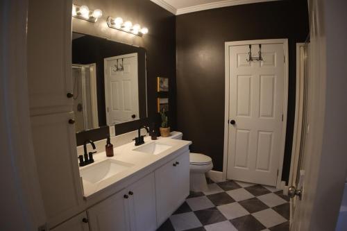 a bathroom with two sinks and a mirror and a toilet at The Gentry Hideaway, A Private Mayberry Retreat in Mount Airy