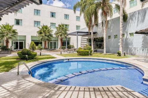 a swimming pool in front of a building at Fiesta Inn Express San Luis Potosí Oriente in San Luis Potosí