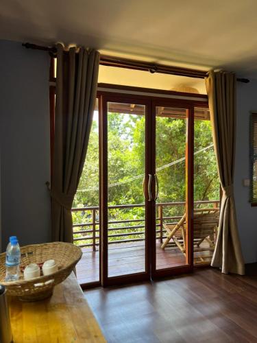 a room with sliding glass doors and a table at The Hideout Koh Rong in Koh Rong