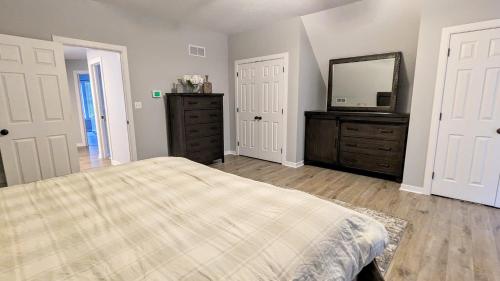 a bedroom with a bed and a dresser and a mirror at The Nest at Pinecrest by AvantStay Spacious Deck Game Room Fire Pit in Pocono Pines