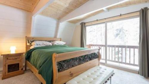a bedroom with a bed and a large window at Zephyr by AvantStay Stylish Modified A Frame w Access To Tahoe Donner in Truckee