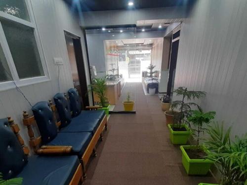 a waiting room with blue chairs and potted plants at Hotel O Graceland in Srīnagar