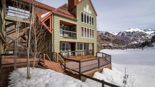 a house with snow on the ground next to a building at Etta Place 1 by AvantStay Ski In Ski Out Unit w Views of the Slopes in Telluride