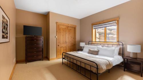 a bedroom with a bed with a television and a window at Highline by AvantStay Breathtaking Mountain Home w Hot Tub Views in Vail