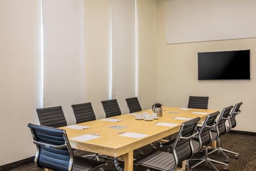 a conference room with a large wooden table and chairs at Fiesta Inn Silao Puerto Interior in Silao