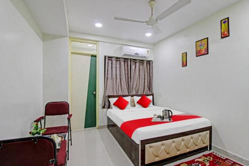 a bedroom with a bed and a chair at Hotel O Sunshine Inn in Nagpur