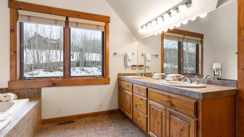 La salle de bains est pourvue d'un lavabo, d'une baignoire et de 2 fenêtres. dans l'établissement Russell Home by AvantStay Expansive Deck Stunning Views Hot Tub, à Telluride