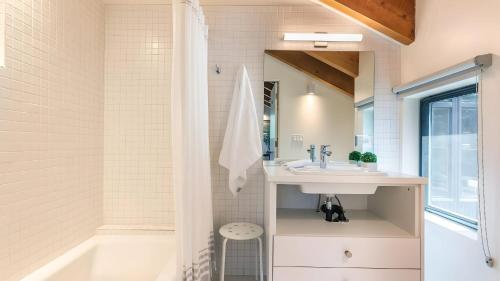a bathroom with a sink and a tub at Trapper by AvantStay A Interior Design w Sauna in Alpine Meadows