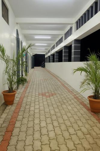 a hallway of a building with potted plants at Kumbha Nivas in Kumbakonam