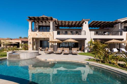 a large house with a swimming pool in front of it at Live Aqua Private Residences Los Cabos in Cabo San Lucas