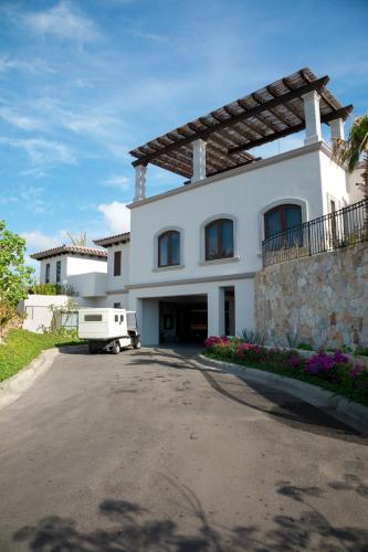 a white house with a van parked in the driveway at Live Aqua Private Residences Los Cabos in Cabo San Lucas