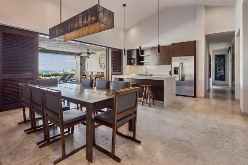 a kitchen with a wooden dining table and chairs at Live Aqua Private Residences Los Cabos in Cabo San Lucas
