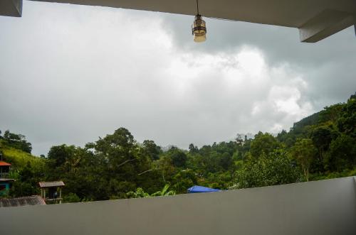 a white wall with a view of a mountain at Ella Bungalow in Ella