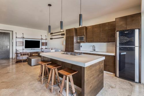 a kitchen with a large island with bar stools at Live Aqua Private Residences Los Cabos in Cabo San Lucas