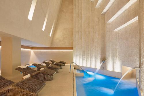 a swimming pool in a hotel with chairs and a swimming pool at Live Aqua Private Residences Los Cabos in Cabo San Lucas