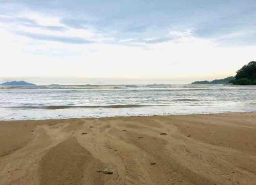 a sandy beach with the ocean in the background at Habitación privada en Playa Dorada in ArraijÃ¡n
