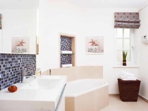 un bagno bianco con vasca e lavandino di Wuldehof a Kampen