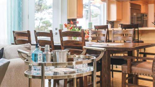 a living room with tables and chairs with bottles on them at Villa Manzanita by AvantStay Hot Tub 1 Block to BeachTown Chefs Kitchen in Manzanita