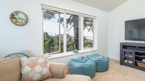 a living room with a couch and a flat screen tv at Villa Manzanita by AvantStay Hot Tub 1 Block to BeachTown Chefs Kitchen in Manzanita