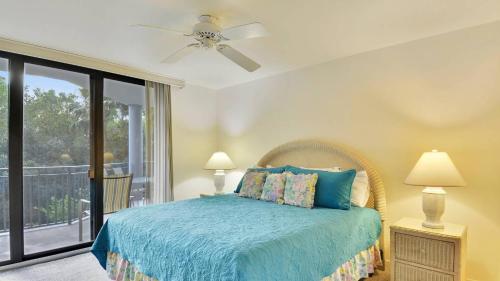 Un dormitorio con una cama azul y un balcón. en Atlantic Paradise by AvantStay Great Location w Balcony Outdoor Dining Shared Pool Hot Tub, en Key West