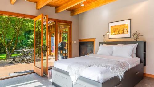 a bedroom with a large bed and a patio at Rhythm Waters by AvantStay Garden Paradise Pond in Langley