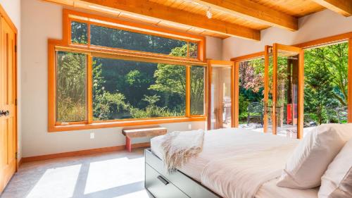 a bedroom with a bed and a large window at Rhythm Waters by AvantStay Garden Paradise Pond in Langley