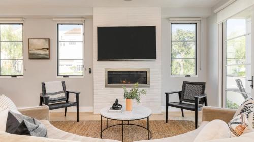 a living room with a fireplace and a flat screen tv at Sea Crown by AvantStay 5mins from the Beach w Multiple Terraces PermitSLP13639 in Newport Beach