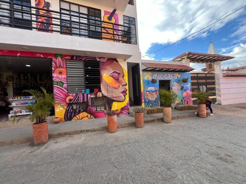 a building with a painting on the side of it at Posada de San Antonio in Ráquira