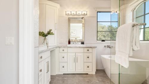 a white bathroom with a tub and a sink at Sea Crown by AvantStay 5mins from the Beach w Multiple Terraces PermitSLP13639 in Newport Beach