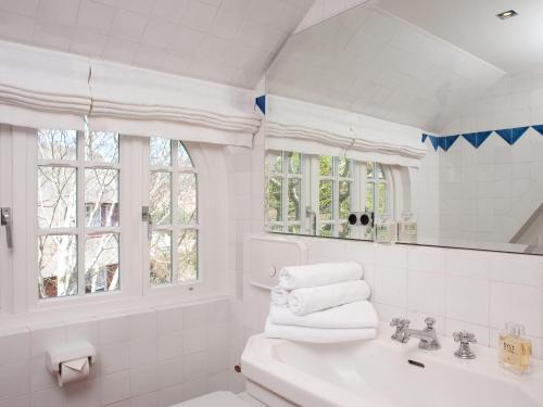 a white bathroom with a sink and a mirror at Vis-a-Vis in Kampen