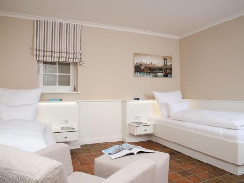 a white room with two beds and a couch at Vis-a-Vis in Kampen